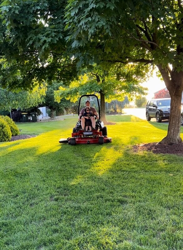 eric and kam on mower owner and his son sitting on a mower